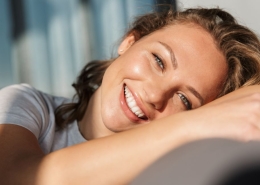 smiling young woman sitting on a sofa